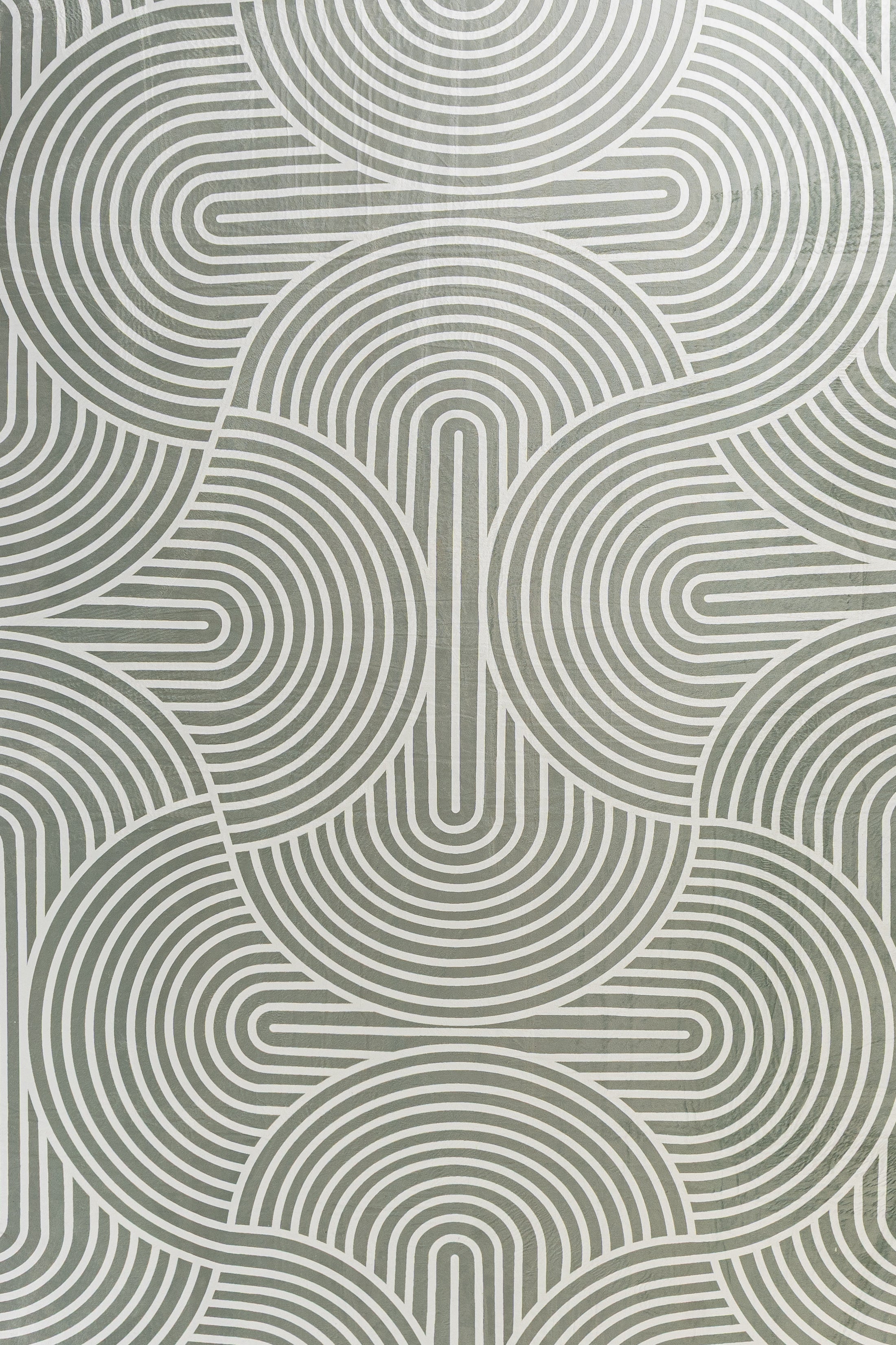 Gray rectangular placemat with a repeating pattern of concentric, arched lines.