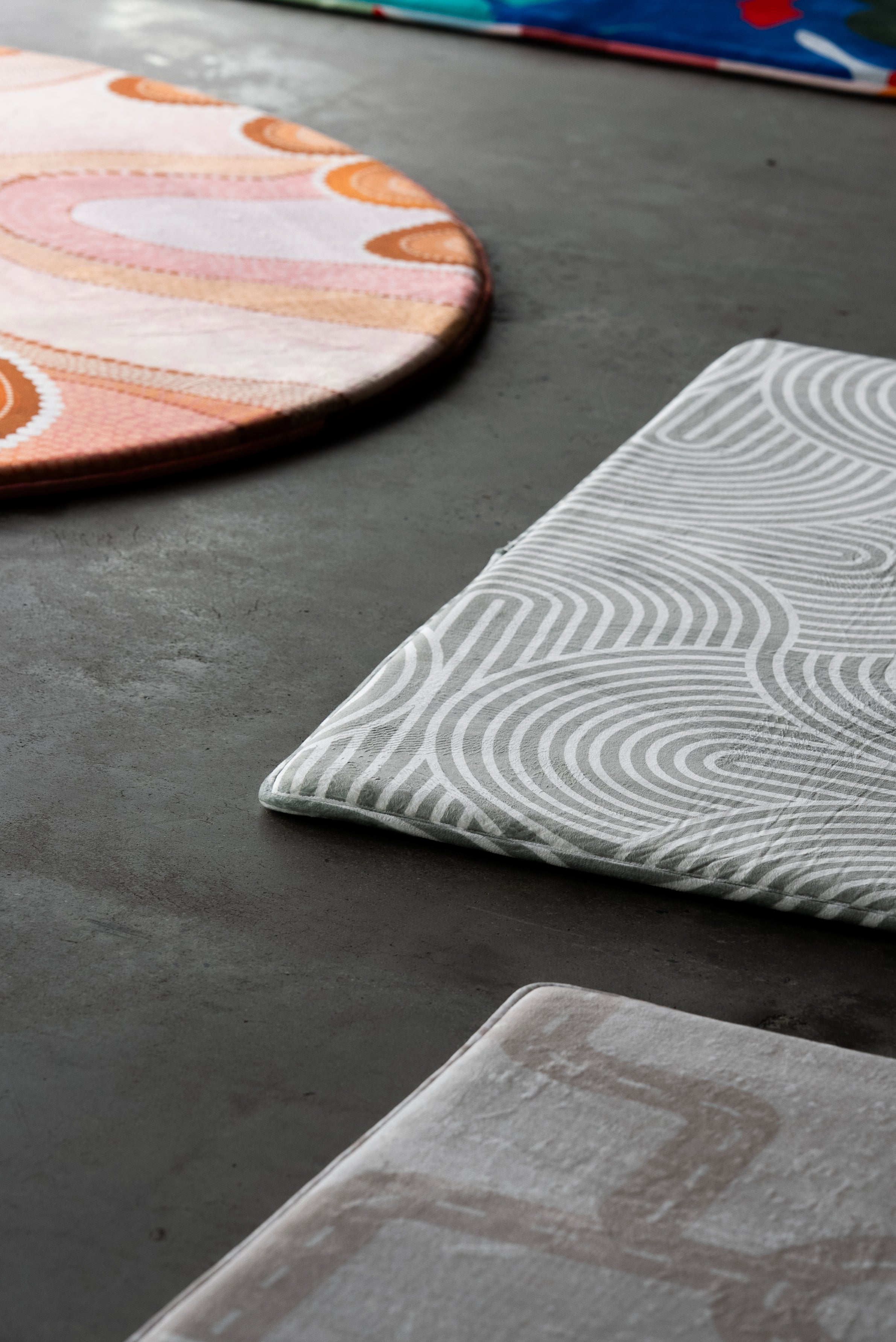  A circular rug adorned with an array of bright, colorful patterns.
