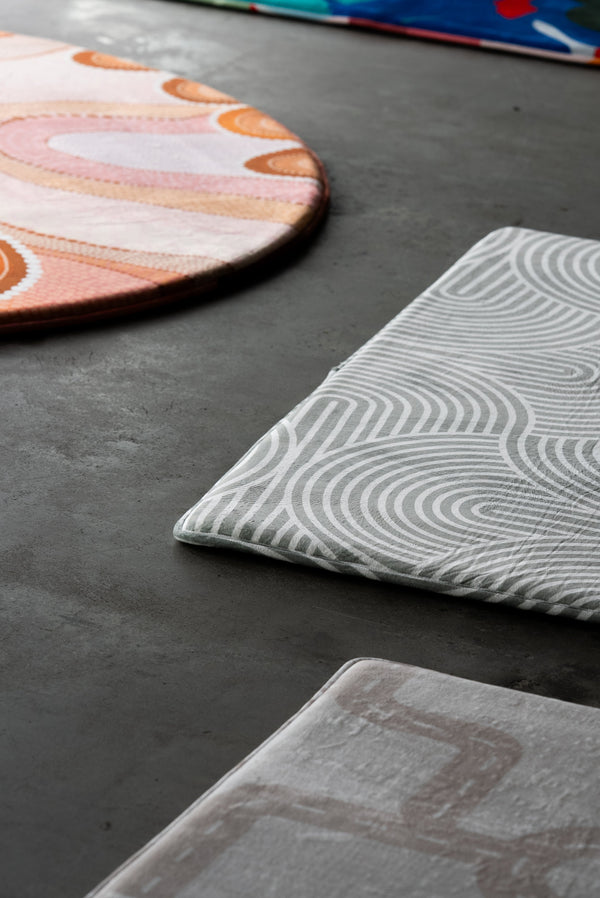  A circular rug adorned with an array of bright, colorful patterns.
