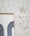 Playmat folded over showing two sided design. Side A has a neutral boho pattern and side B has a track design.