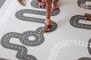 Kids playing with wooden toys on Baby Driver Boho playmat. Side B has a car track design.