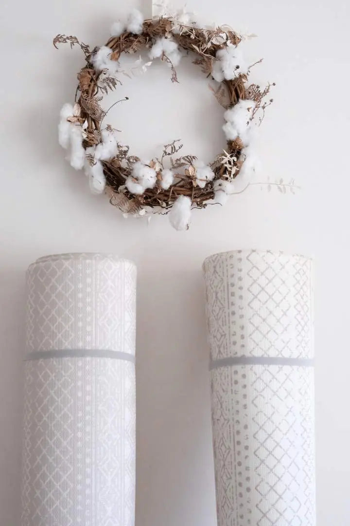 Two playmats showing the two prints. One side is a white boho design and the other is a grey boho design.