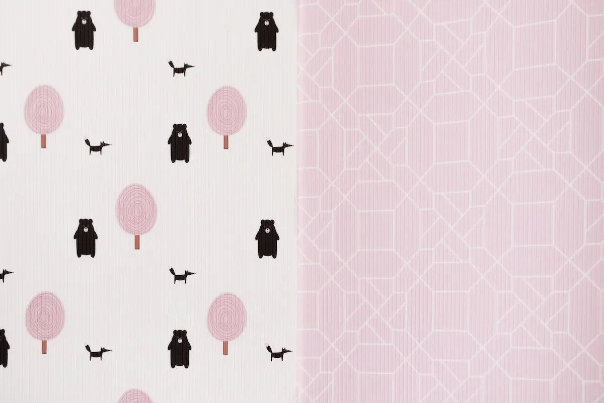 Two sides of Forrest Blush playmat. Side A has a pink geometric pattern and side B has a tree and bear pattern. 
