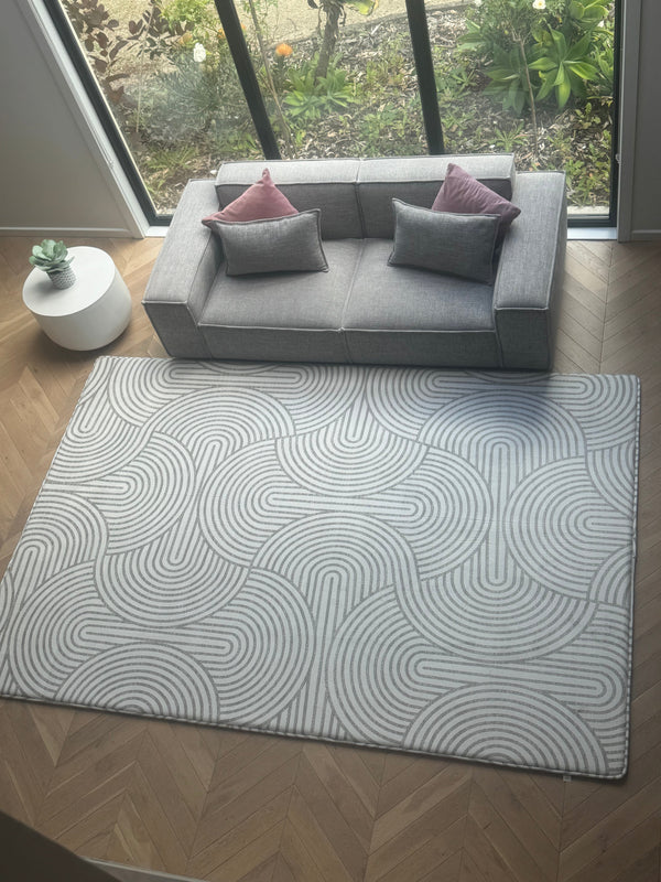  A cozy living room featuring a rug, a couch, and a warm fireplace, creating a welcoming atmosphere.