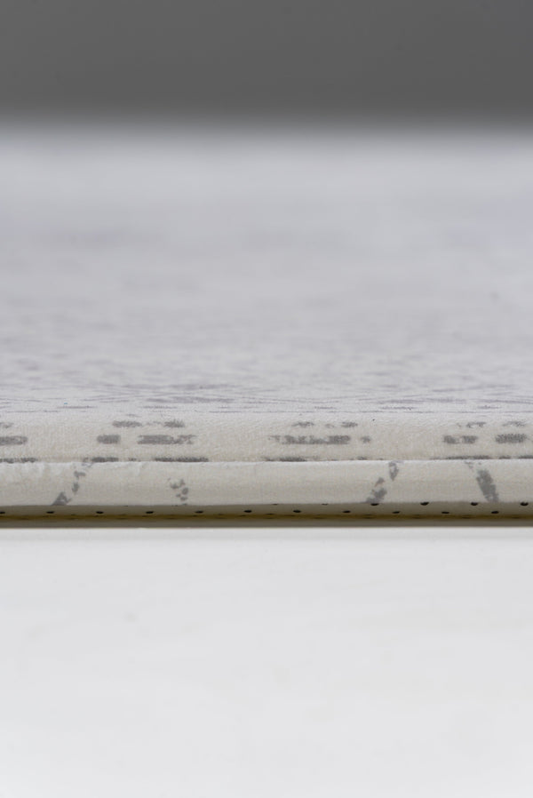 A white rug adorned with a geometric pattern, adding a contemporary touch to the room's decor.