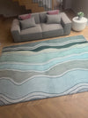 A wave-patterned rug in a living room, enhancing the room's decor with its fluid design.