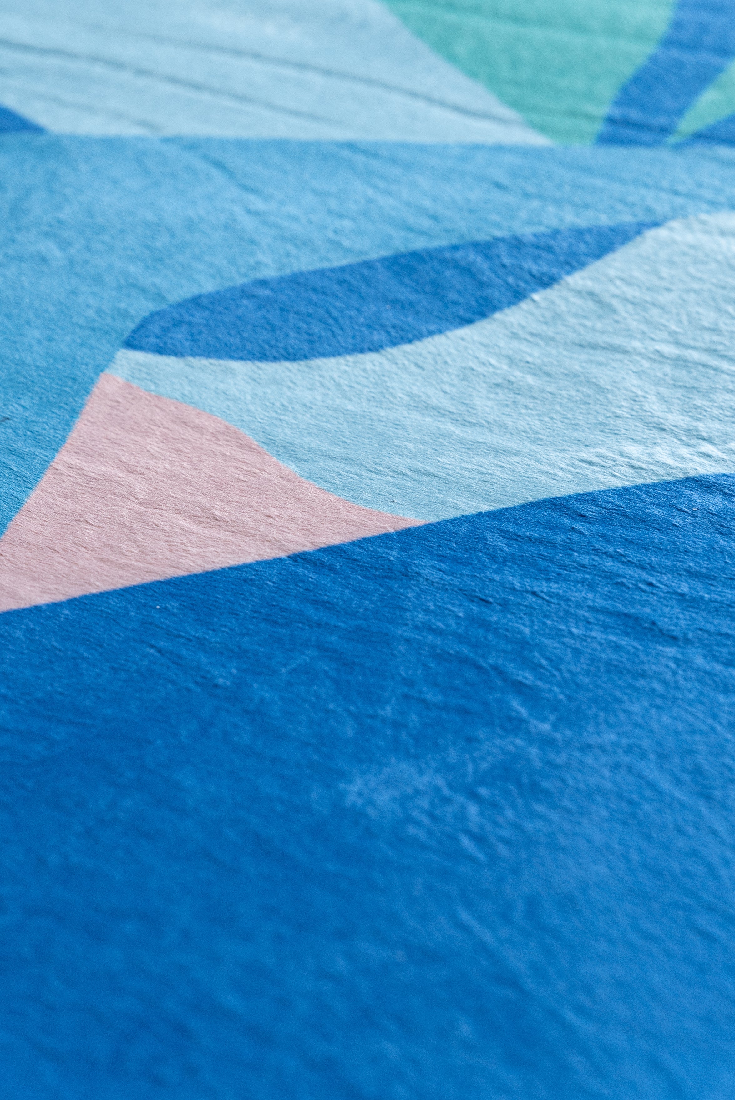 A bright, patterned rug in a living room with a couch and a window, contributing to a cheerful ambiance.